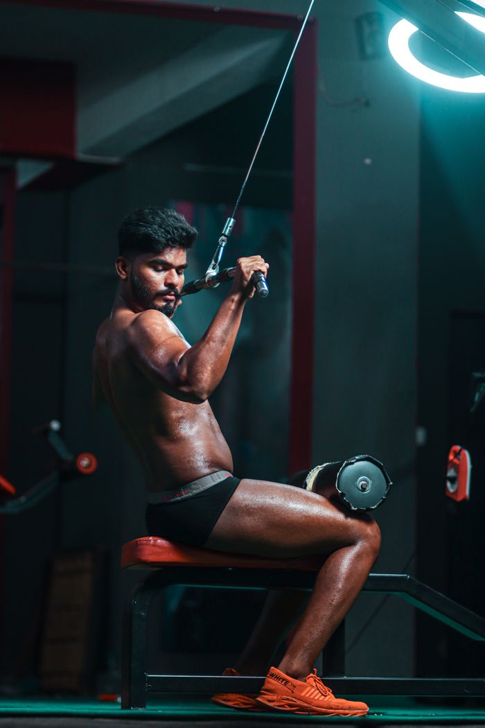 why-choose-us A focused man performing a cable workout, showcasing dedication and strength in a gym setting.