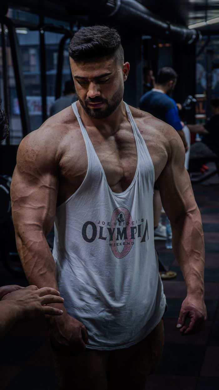 gallery-4 Strong muscular man in a gym focusing on bodybuilding and strength training.
