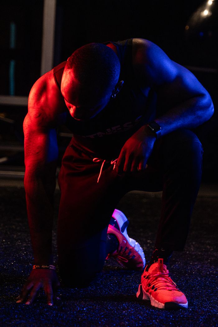 gallery-5 Powerful pose of an athlete in dynamic lighting, showcasing strength and determination.